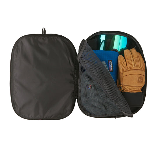 Patagonia Black Hole Cube 14L in black on black with various ski gear inside