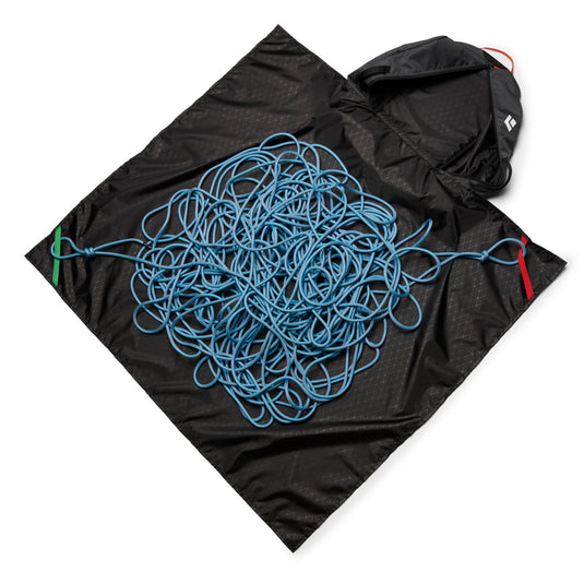 Black Diamond Stone 42 duffel bag in carbon with rope tarp laid out with blue rope attached.