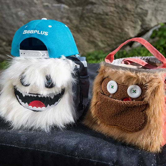 8b+ Herman Chalk Bucket in white fur design with louie chalk bucket in orange fur design on boulder pad outside