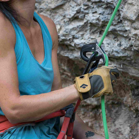 Black Diamond ATC pilot belay device in black in use by female climber with green rope.