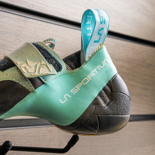 A close up of La Sportiva Skwama vegan womens heel, resting on black hook against metallic background.