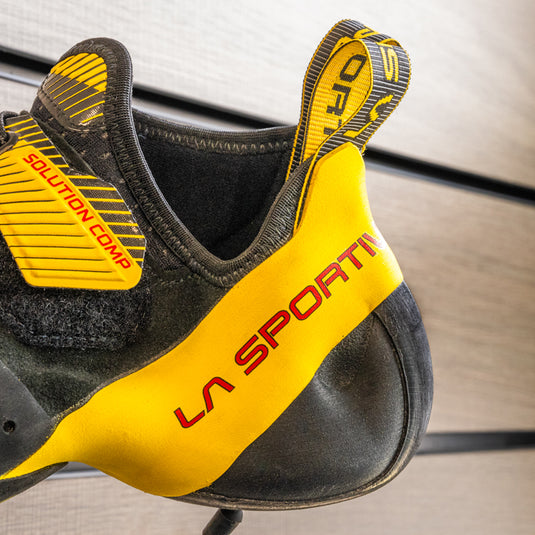 A close up of La Sportiva solution comp heel, resting on black hook against metallic background.
