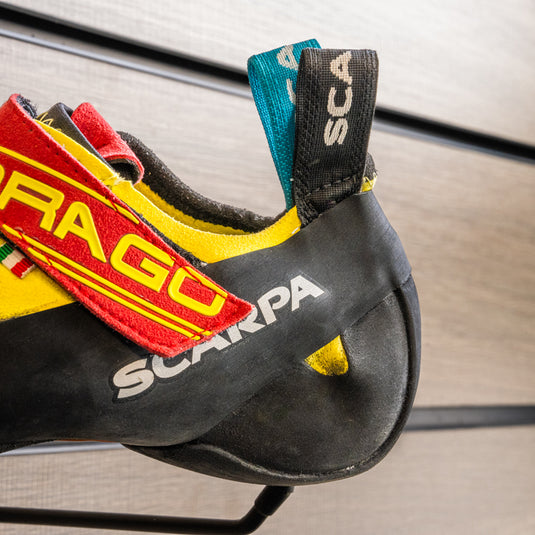 A close up of Scarpa Drago heel, resting on black hook against metallic background.