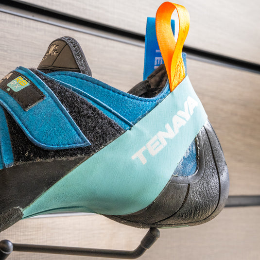 A close up of Tenaya Mastia heel, resting on black hook against metallic background.