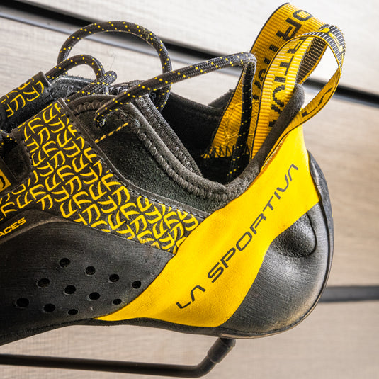 A close up of La Sportiva Katana Lace heel, resting on black hook against metallic background.