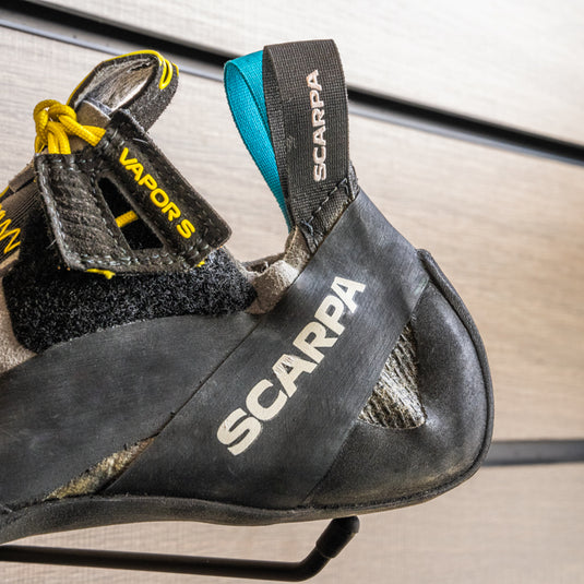 A close up of Scarpa Vapour S heel, resting on black hook against metallic background.