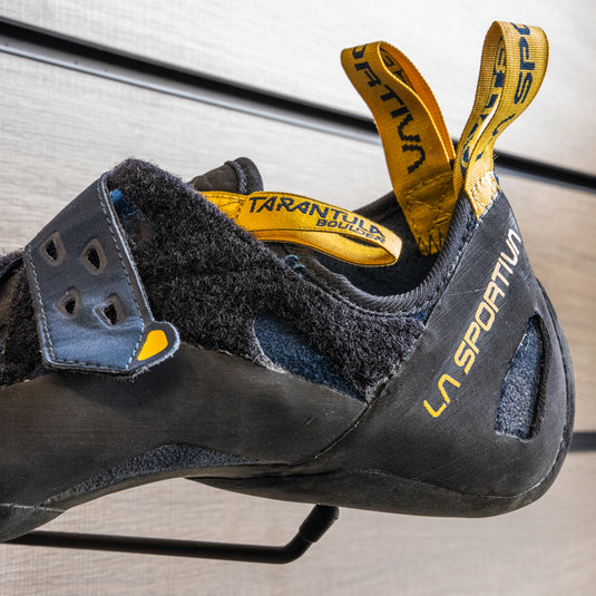 A close up of La Sportiva Tarantula Boulder Heel, resting on black hook against metallic background.