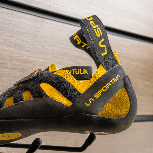 A close up of La Sportiva Tarantula junior heel, resting on black hook against metallic background.