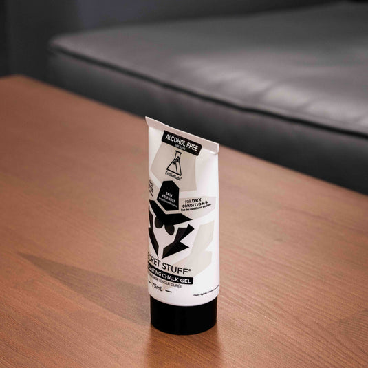 One 75ml tube of Friction Labs Secret Stuff Liquid Chalk Alcohol-Free in black and white design. The tube is turned on its side and displayed on a wooden surface.