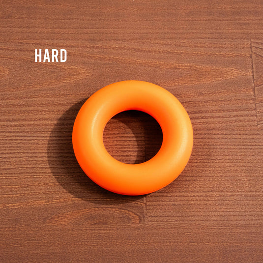 Orange Forearm trainer ring on wooden surface with the text hard in the background
