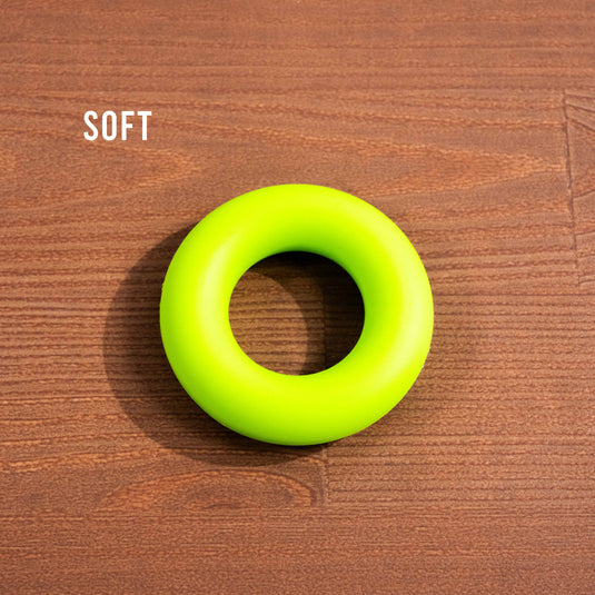 Green Forearm trainer ring on wooden surface with the text soft in the background
