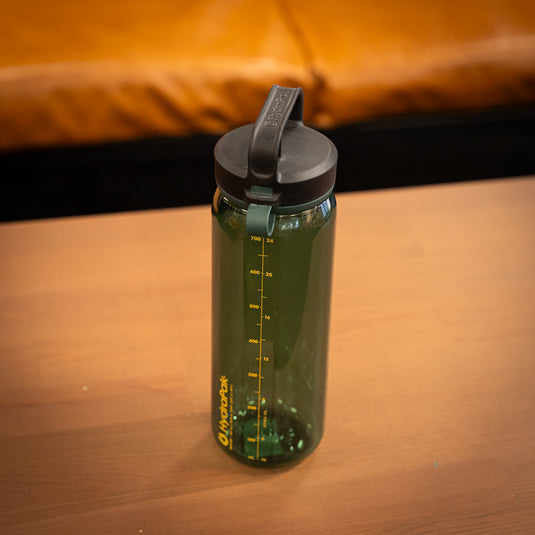 750ml Hyrapak Water Bottle in green displayed stood up on wooden surface.