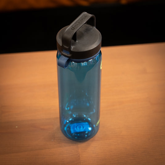 Hyrapak Water Bottle in blue displayed stood up on wooden surface.