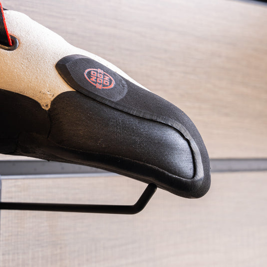 A close up La Sportiva Futura toe box, resting on black wall hook against metallic background.
