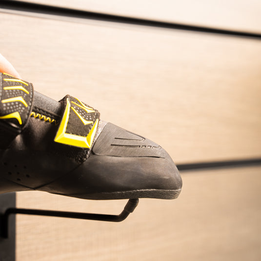 A close up Scarpa Vapour V toe box, resting on black wall hook against metallic background.