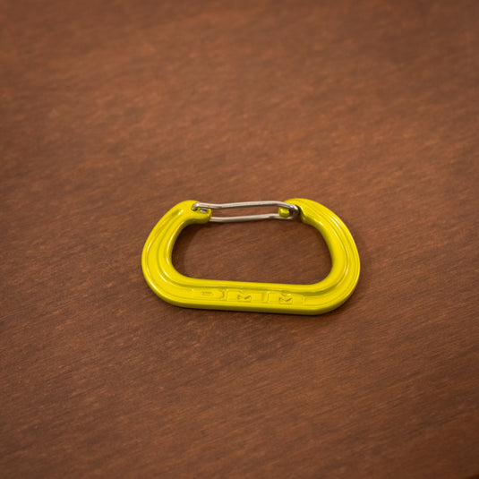 Wire gate mini carabiner in Lime, laid on wooden surface