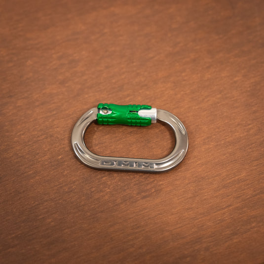 mini locksafe carabiner in titanium and green, laid on wooden surface
