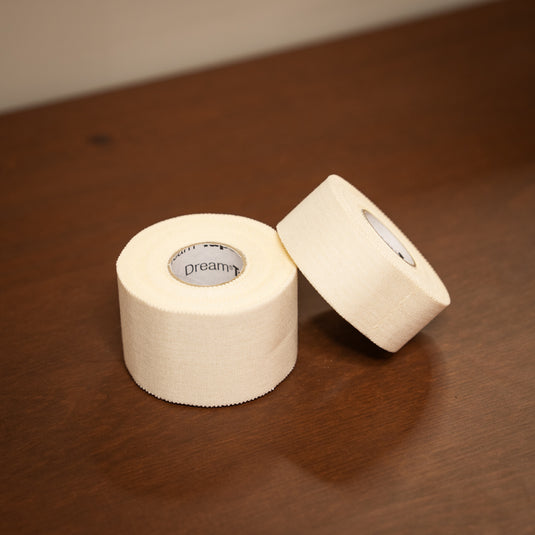 Two rolls of Beta Climbing Tape. One thick roll and one thinner roll, displayed on wooden surface.