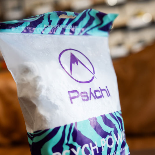 Close up of Psychi Chalk in purple and green packaging.