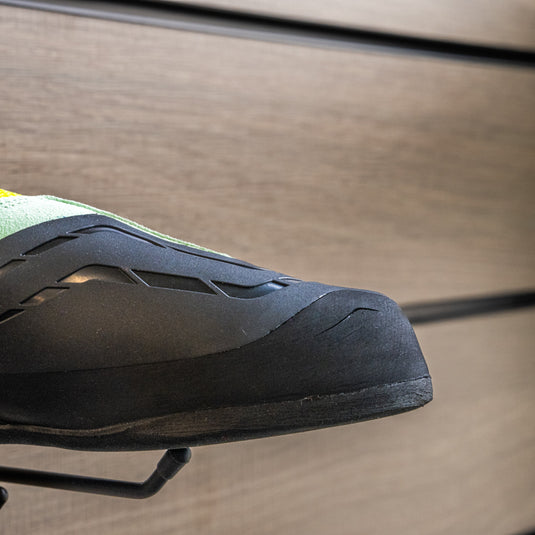 A close up Scarpa Origin VS Women toe box, resting on black wall hook against metallic background.