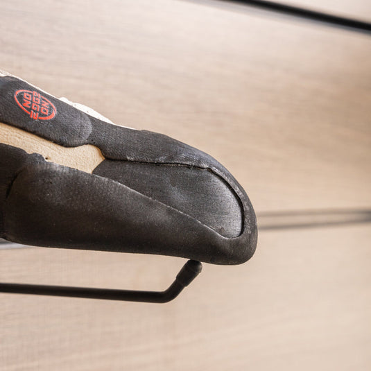 A close up La Sportiva Mantra toe box, resting on black wall hook against metallic background.