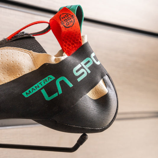 A close up La Sportiva Mantra Heel, resting on black wall hook against metallic background.