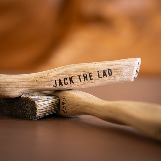 Two Jack the Lad Climbing brush resting on wooden surface. Jack the Lad engraved on the handle and brush ID number 2090.