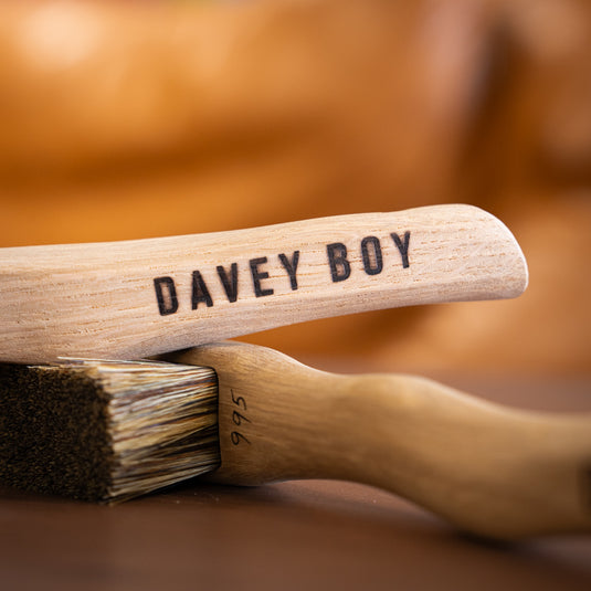 Two Davey Boy Silly Goat brushes resting on wooden surface. Davey Boy engraved on the handle and brush ID number 995