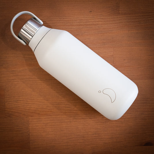 Grey 500ml chilly's water bottle with stainless steel lid displayed on wooden surface lay down