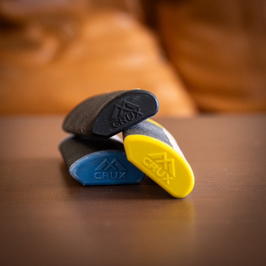 three varients of Crux Skin File in yellow, blue and black laid on wooden surface