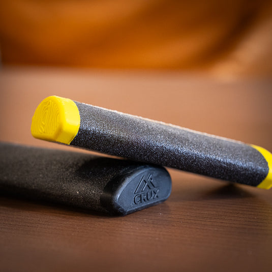two varients of Crux Skin File in yellow and black laid on wooden surface