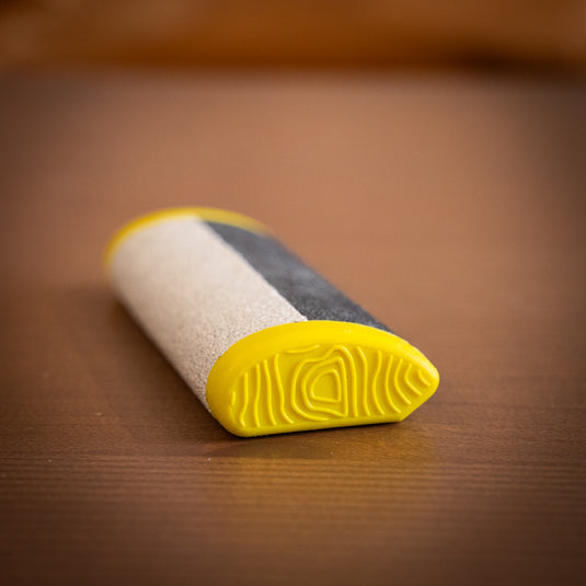 Yellow Crux Skin File in yellow laid on wooden surface
