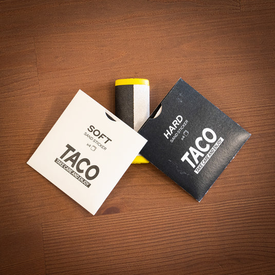 Yellow Crux Skin File laid on wooden surface with two replacement packets in white (SOFT) and black (HARD) packets.