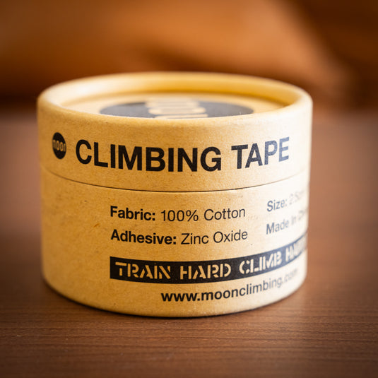 Close up of MOon Tape cardboard packaging with text Fabic: 100% cotton and Adhesive: Zinc Oxide.
Displayed on wooden surface