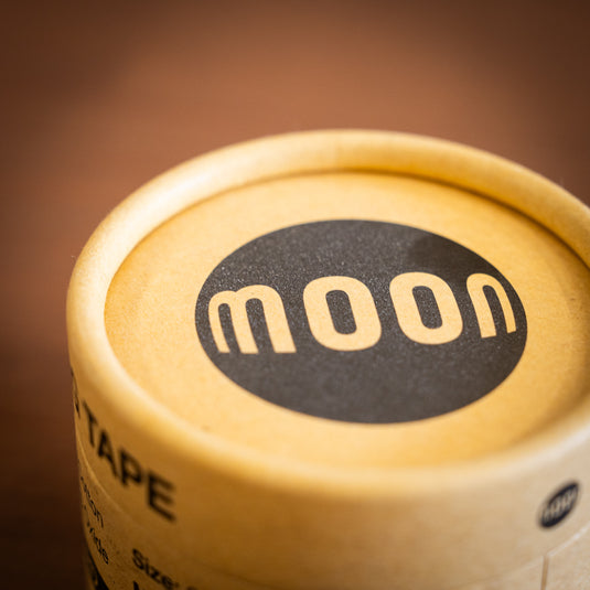 Close up of Cardboard packaging with the logo moon in black.