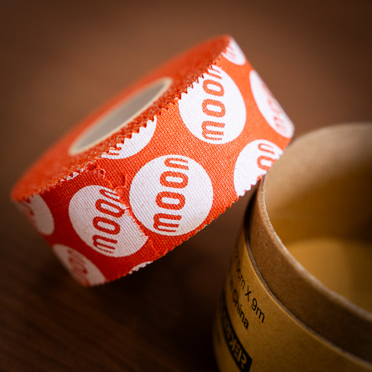 Close up of Moon Tape - in bright orange with repeating moon logo.