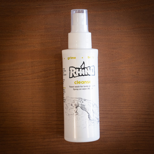 White spray bottle labeled "Rhino Cleanse - Travel wash for body and gear. Spray on wipe off, go!"