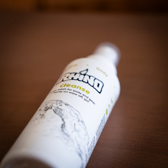 White spray bottle labeled "Rhino Cleanse - Travel wash for body and gear. Spray on wipe off, go!"