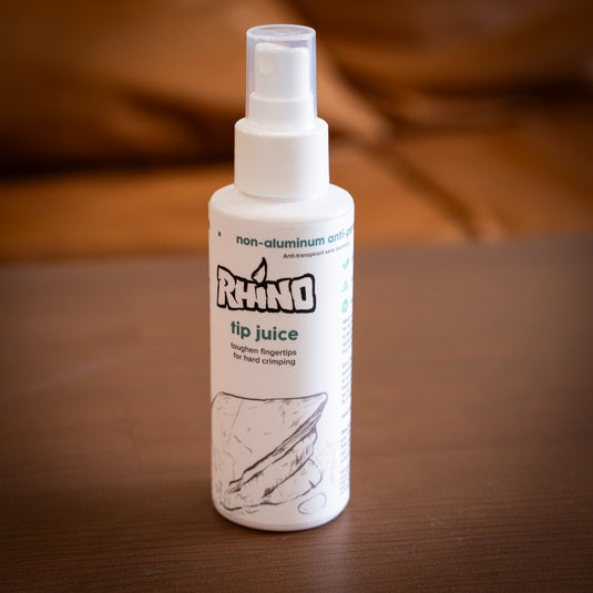Large spray bottle of Rhino tip juice - toughen fingertips for hard crimping, on wooden surface