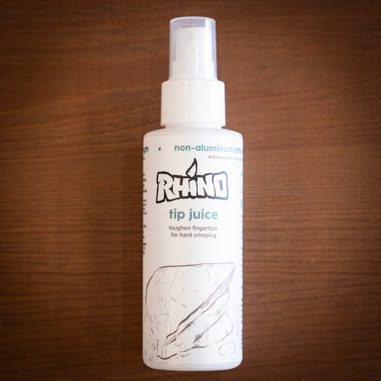 Large spray bottle of Rhino tip juice - toughen fingertips for hard crimping, on wooden surface