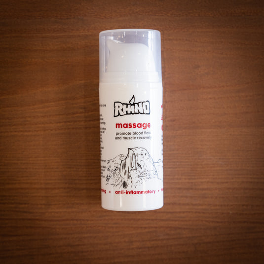 Pump bottle of Rhino Massage - promote blood flow and muscle revovery. Displayed on wooden surface.