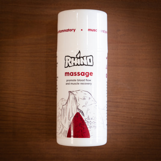 Larger pump bottle of Rhino Massage - promote blood flow and muscle revovery. Displayed on wooden surface.