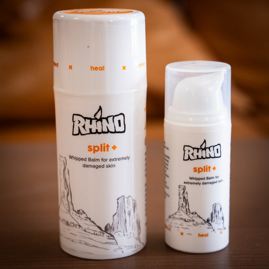 Two pump bottles of Rhino split+ whipped balm for extremely damaged skin, one large and one small, on a wooden surface.