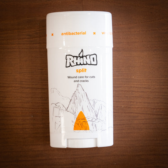 Large container of Rhino split wound care for cuts and cracks laid on a wooden surface.