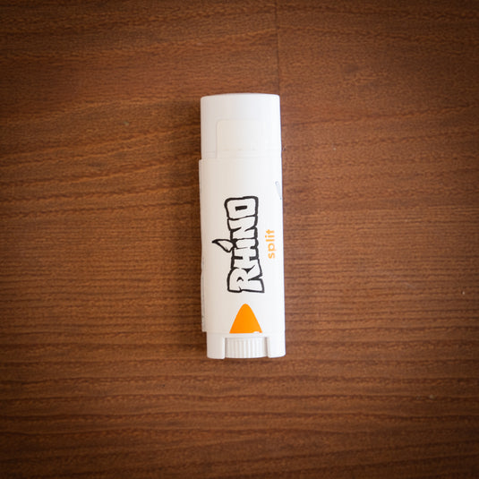 Small lip-tube sized container of Rhino split wound care for cuts and cracks laid on a wooden surface.