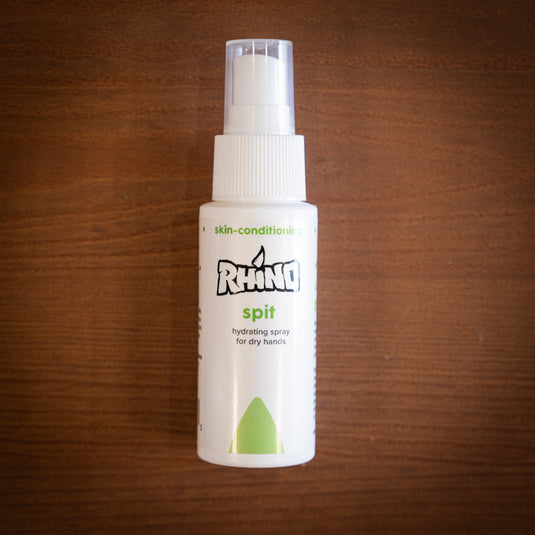 Small spray bottle of Rhino Spit - hydrating spray for dry hands. Displayed on wooden surface.