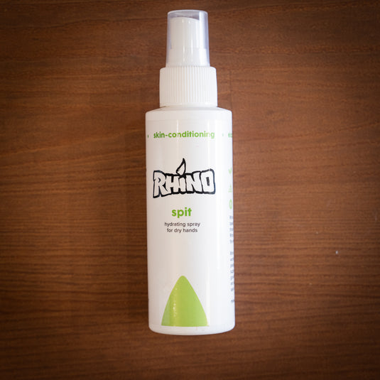 Medium spray bottle of Rhino Spit - hydrating spray for dry hands. Displayed on wooden surface.