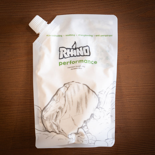 Large refill pouch of Rhino Skin Performance - maintain tough, dry durable skin. White and green design, displayed on wooden surface.