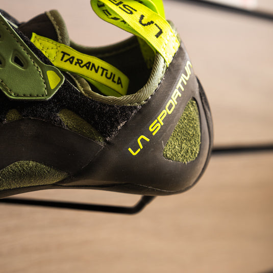 A close up of La Sportiva Tarantula heel, resting on black hook against metallic background.