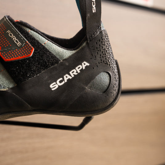 A close up of Scarpa Force womens heel, resting on black hook against metallic background.